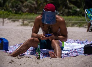 ¿Puede este fin de semana de vacaciones disparar otra ola de casos de COVID? Hombre viste su protector facial EFE