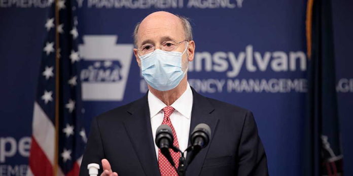 Governor-Wolf-at-a-podium-with-a-mask
