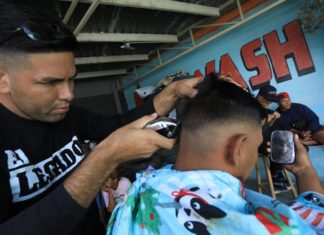 Venezolanos varados en la frontera de México subsisten como barberos