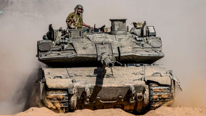 Soldados del ejército israelí conducen un tanque en un lugar cerca de la frontera con la Franja de Gaza, en el sur de Israel, el 5 de mayo de 2024.